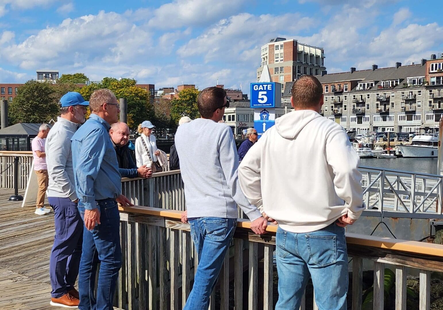 A group of people standing on top of a wooden deck.